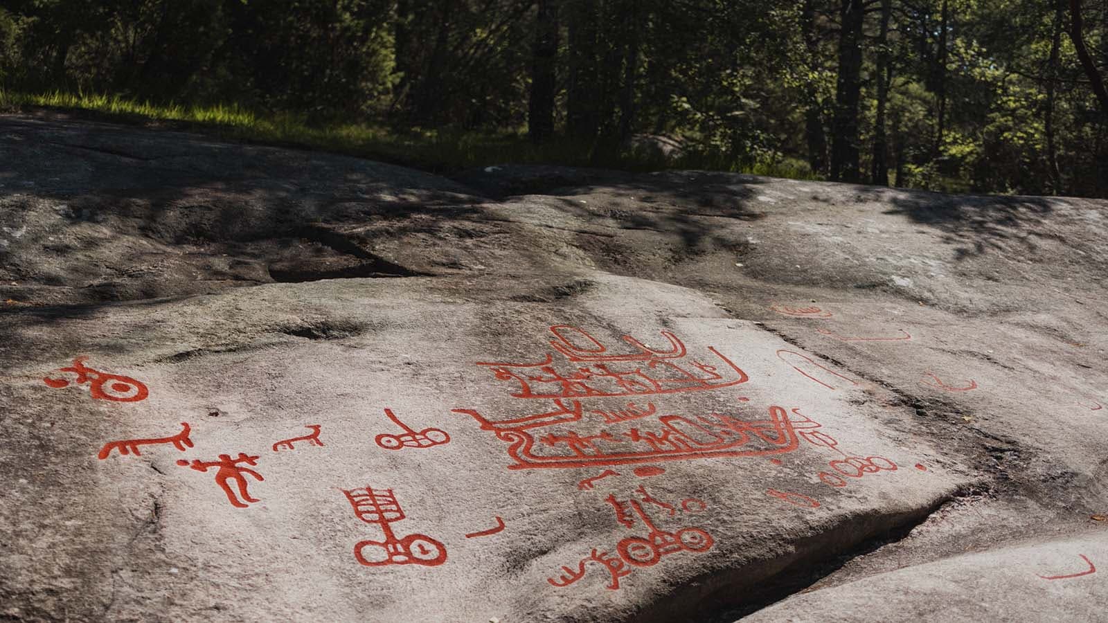 Helleristninger på Begbyfeltet i Fredrikstad, rødmalte figurer på fjell.