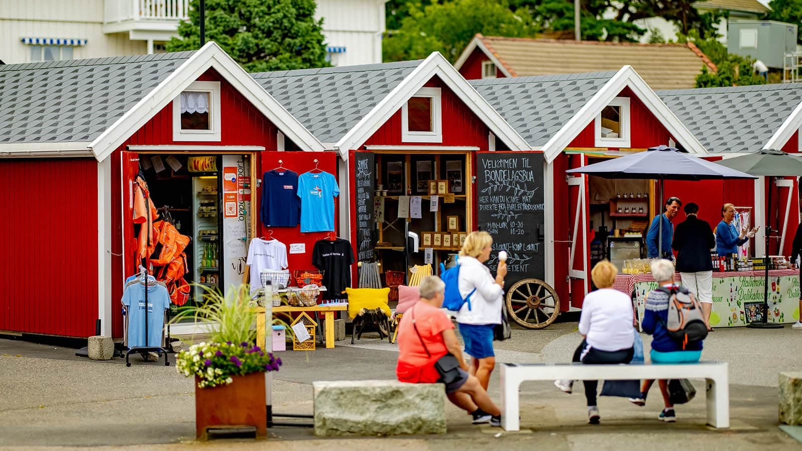 Torghandel med boder, lokalmat og besøkende en sommerdag.